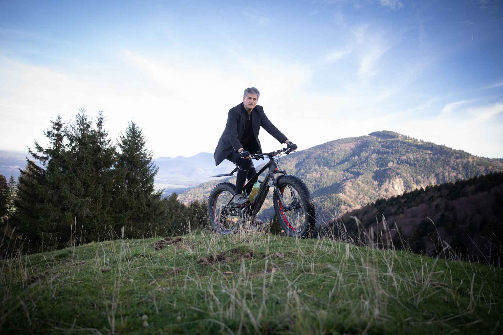 Steigauf-Geschäftsführer Roul Steigauf auf einem Mountainbike in den Vorlapen. Er trägt einen Anzug.